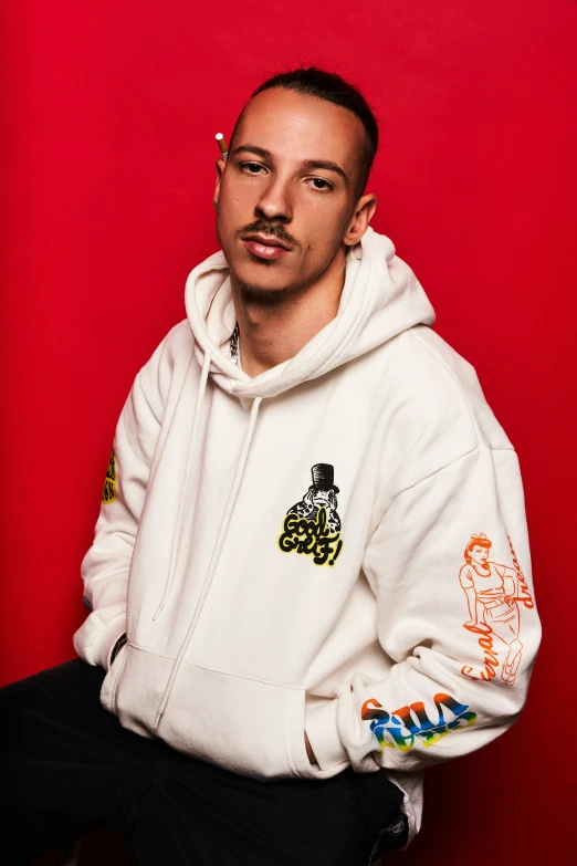 a man posing for a po while wearing a white sweatshirt