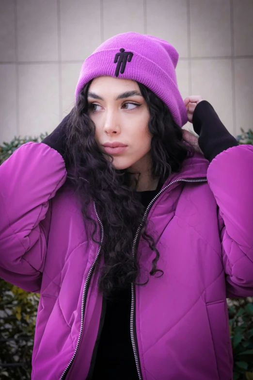 a  is standing with her head on her shoulders wearing a purple jacket and a matching hat