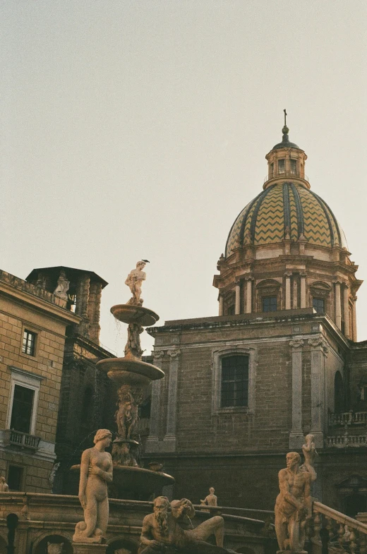 this old building has some fountains in the front and a large dome