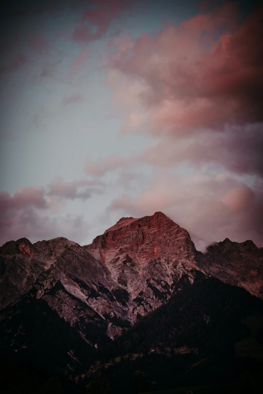 a mountain range with snow capped mountains and clouds