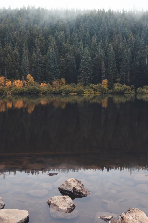 two rocks are in the middle of a lake