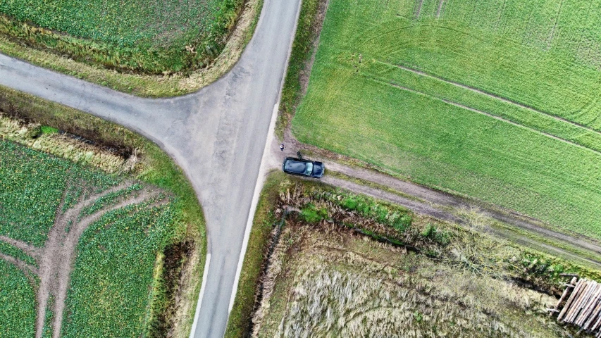 an overhead view of a country road and a small farm