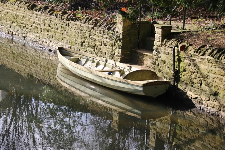 a small boat sitting on a river bank