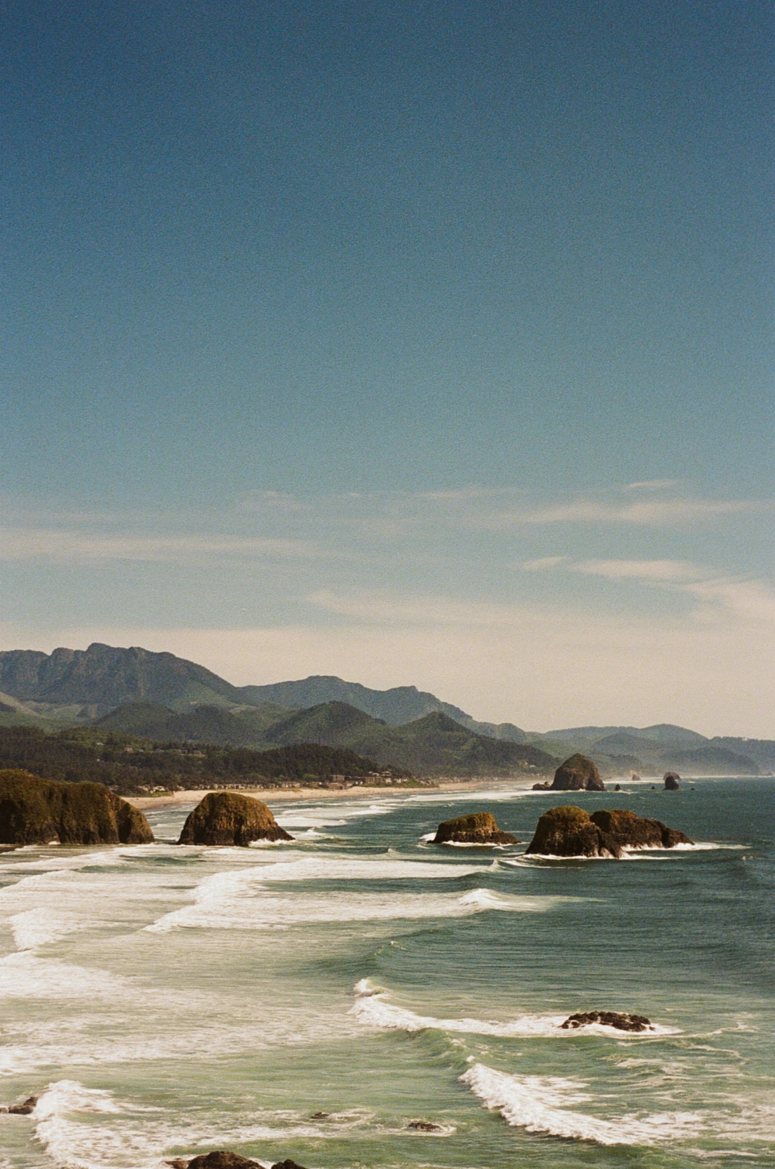 a beautiful beach view with hills in the background