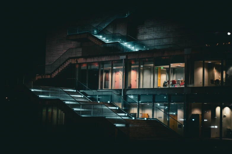 an architectural building lit up at night with lights in it