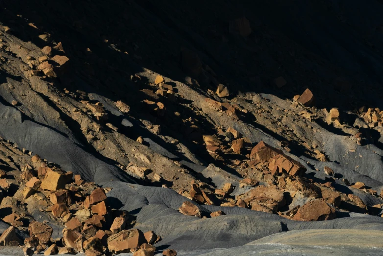 a brown and black rock formation near some mountains