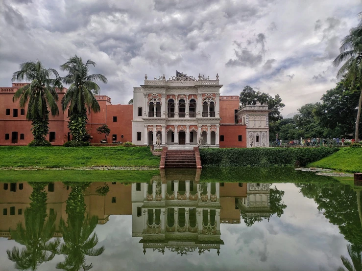 a large red building sits next to a body of water