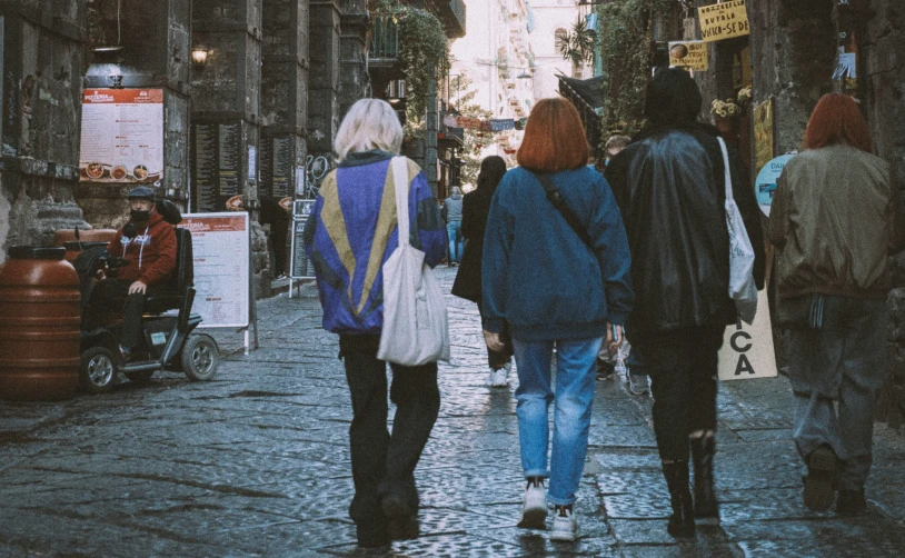 a group of people walking down a cobblestone walkway