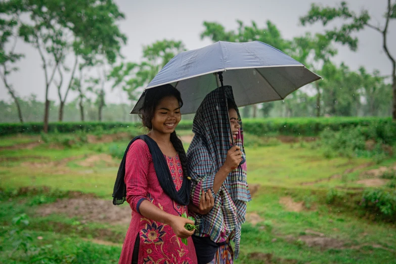 two people walking under an umbrella in the rain