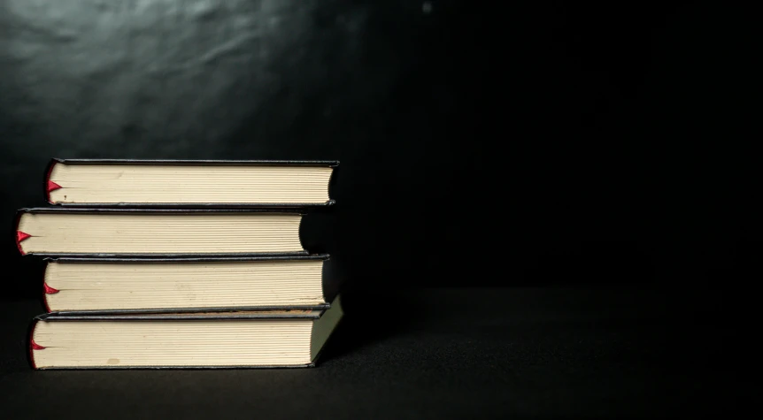 four open books stacked on top of each other on a table