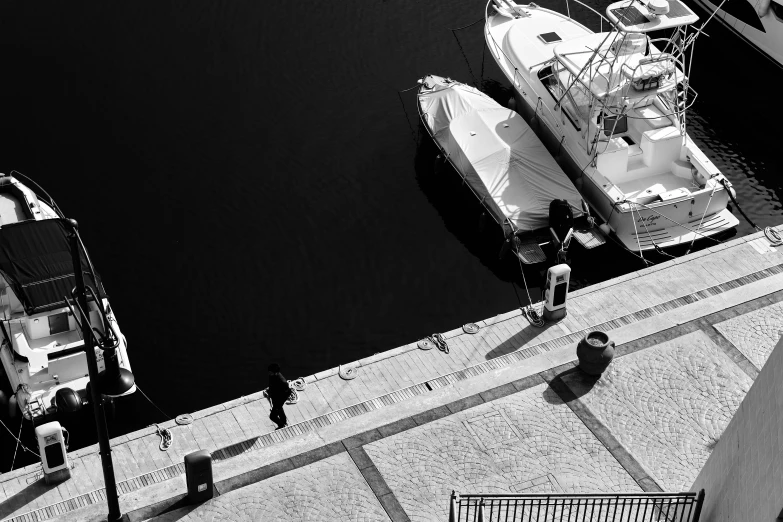 a man walking towards boats in the water