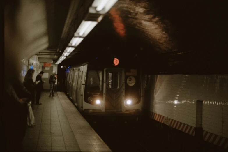 people walking on the platform and a subway train