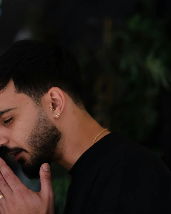 a young man holding up a cellphone to his ear