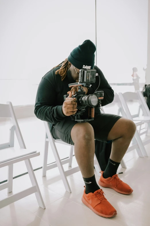 man in orange tennis shoes taking pos with camera