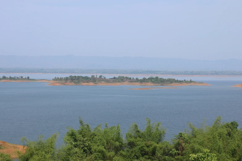 a large body of water surrounded by green trees