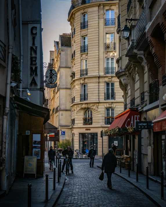 people walk down a street in a city at dusk