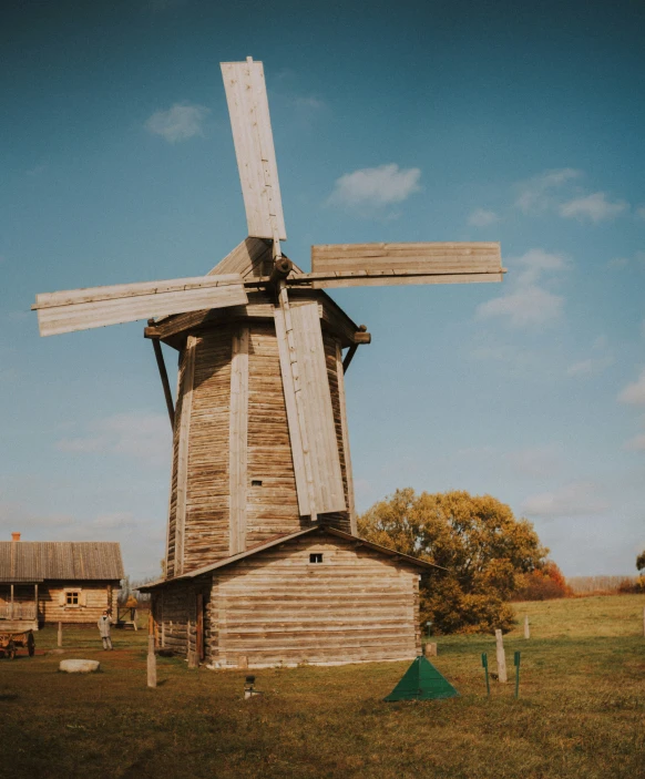 an old windmill sitting in the middle of a grassy field