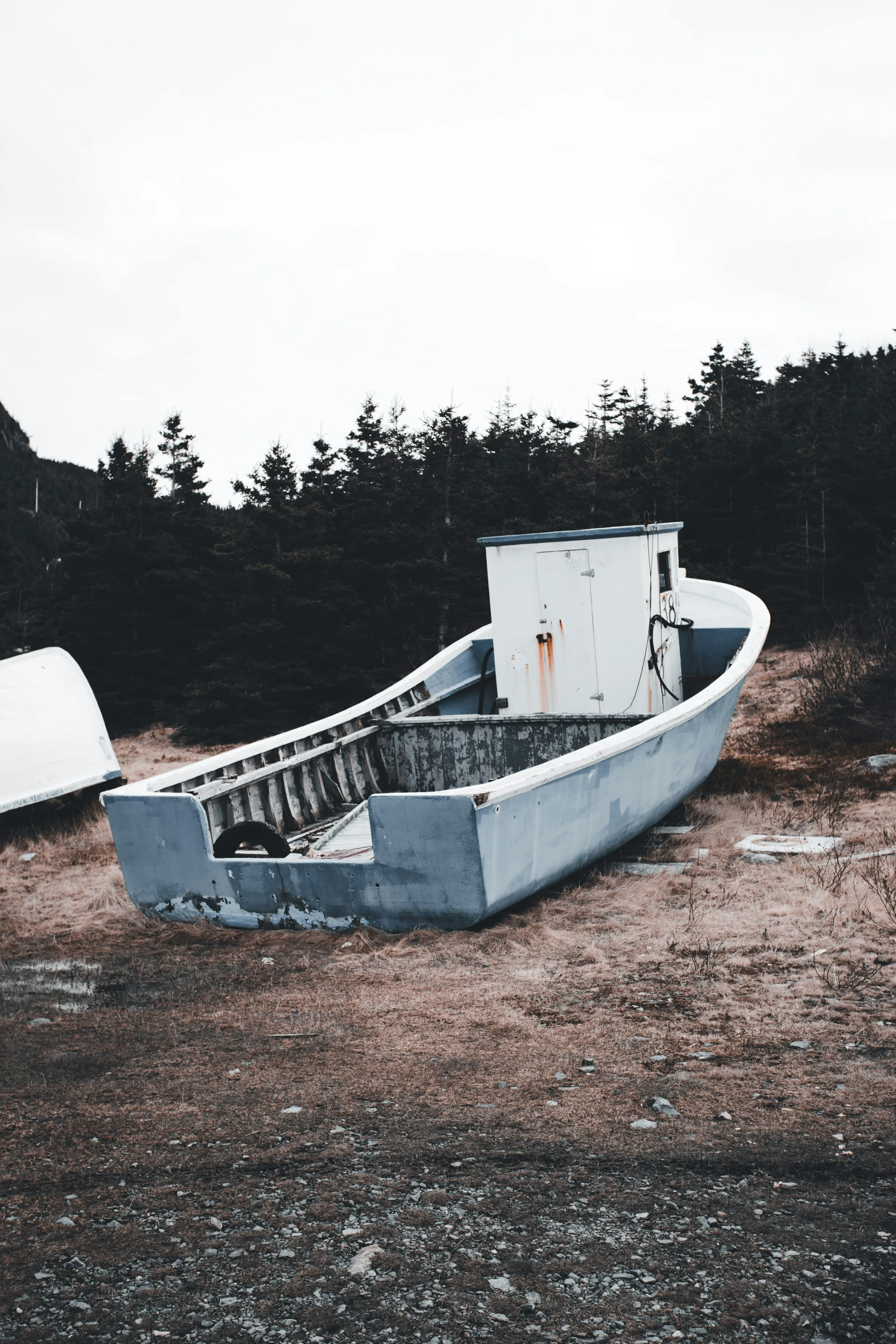 a canoe sitting on top of a dry grass field