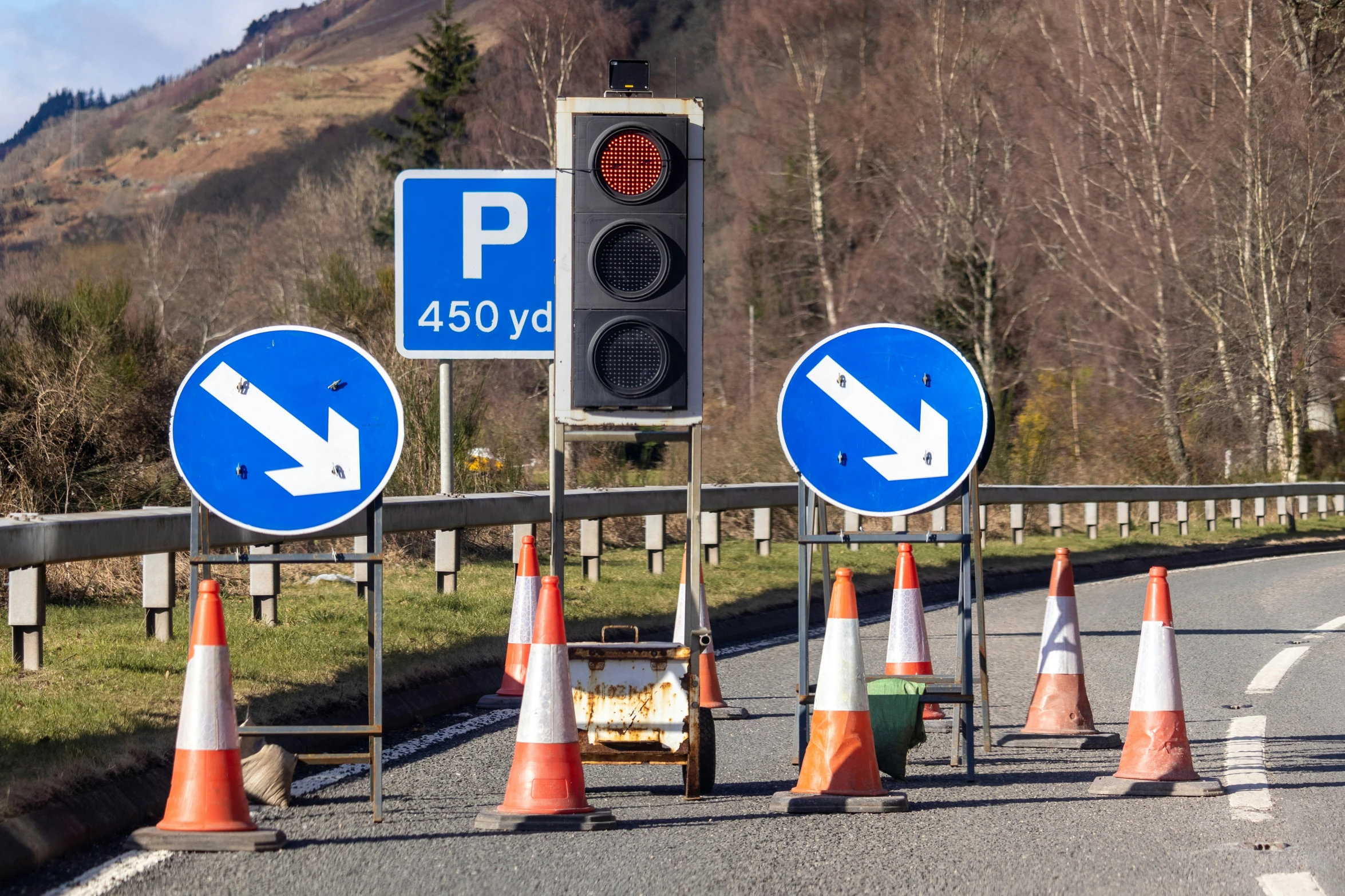 blue traffic sign with arrows pointing to left