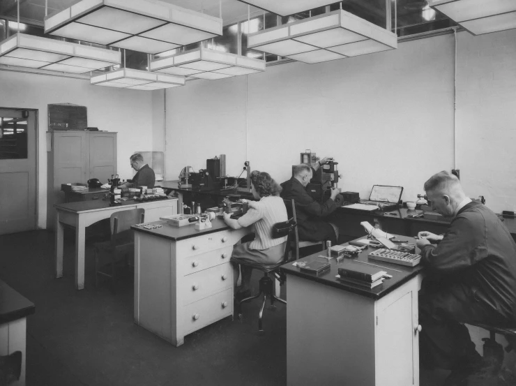 a couple of men sitting at desk in a room