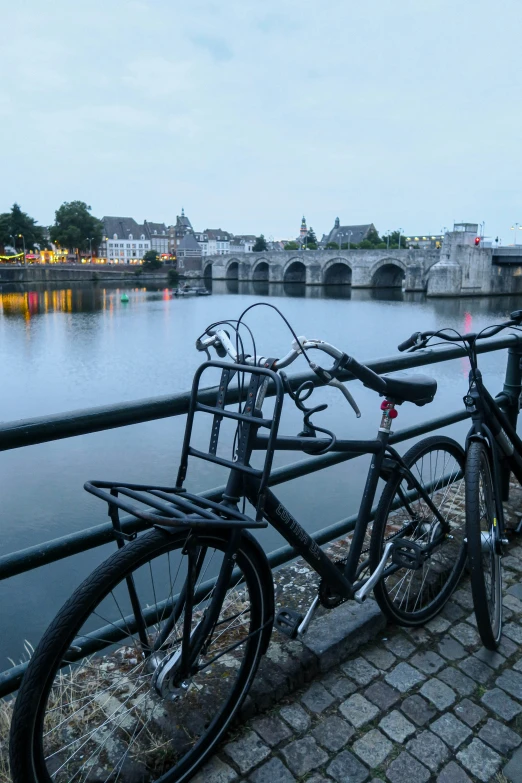 bicycles on a bridge over the water during the evening