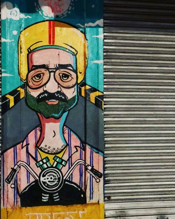 graffiti on side of building features an image of a man wearing a gold crown and a mustache