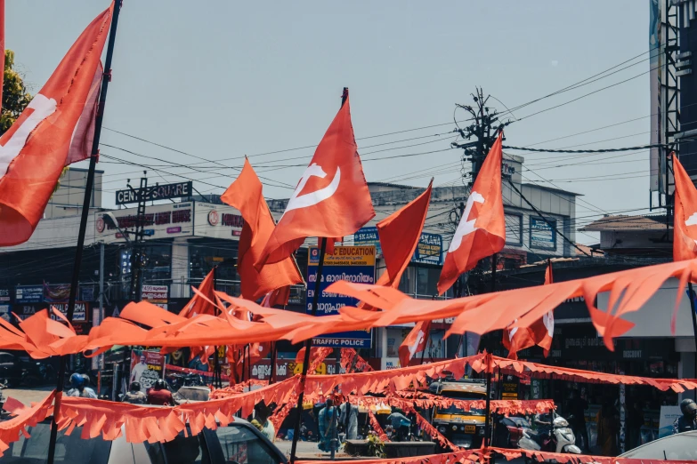 the orange flags are hanging upside down near a city