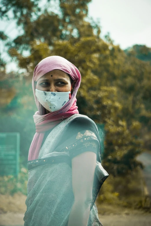 a woman wears a mask as she poses for a po