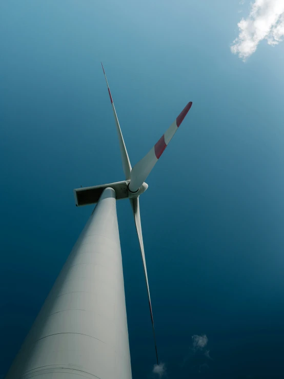 there is a white windmill and some clouds