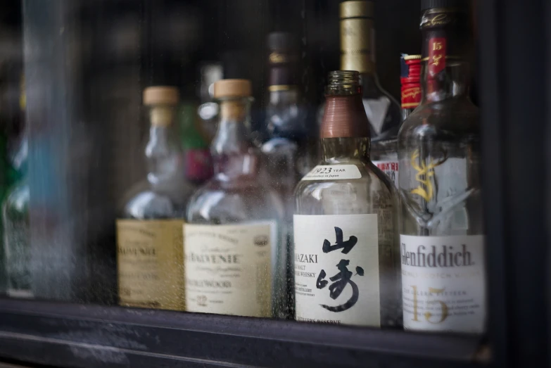 several empty bottles are on a shelf with a black frame