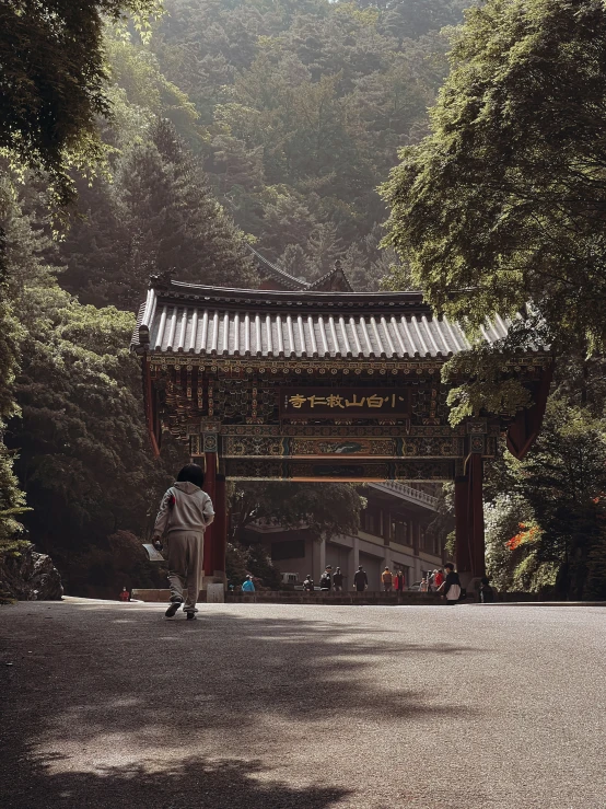 a man in a hat walking towards a covered area