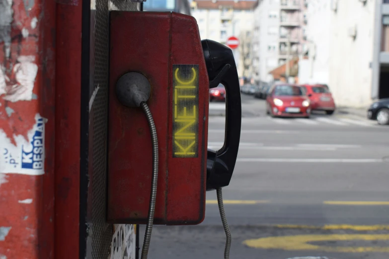 an old phone attached to a street curb