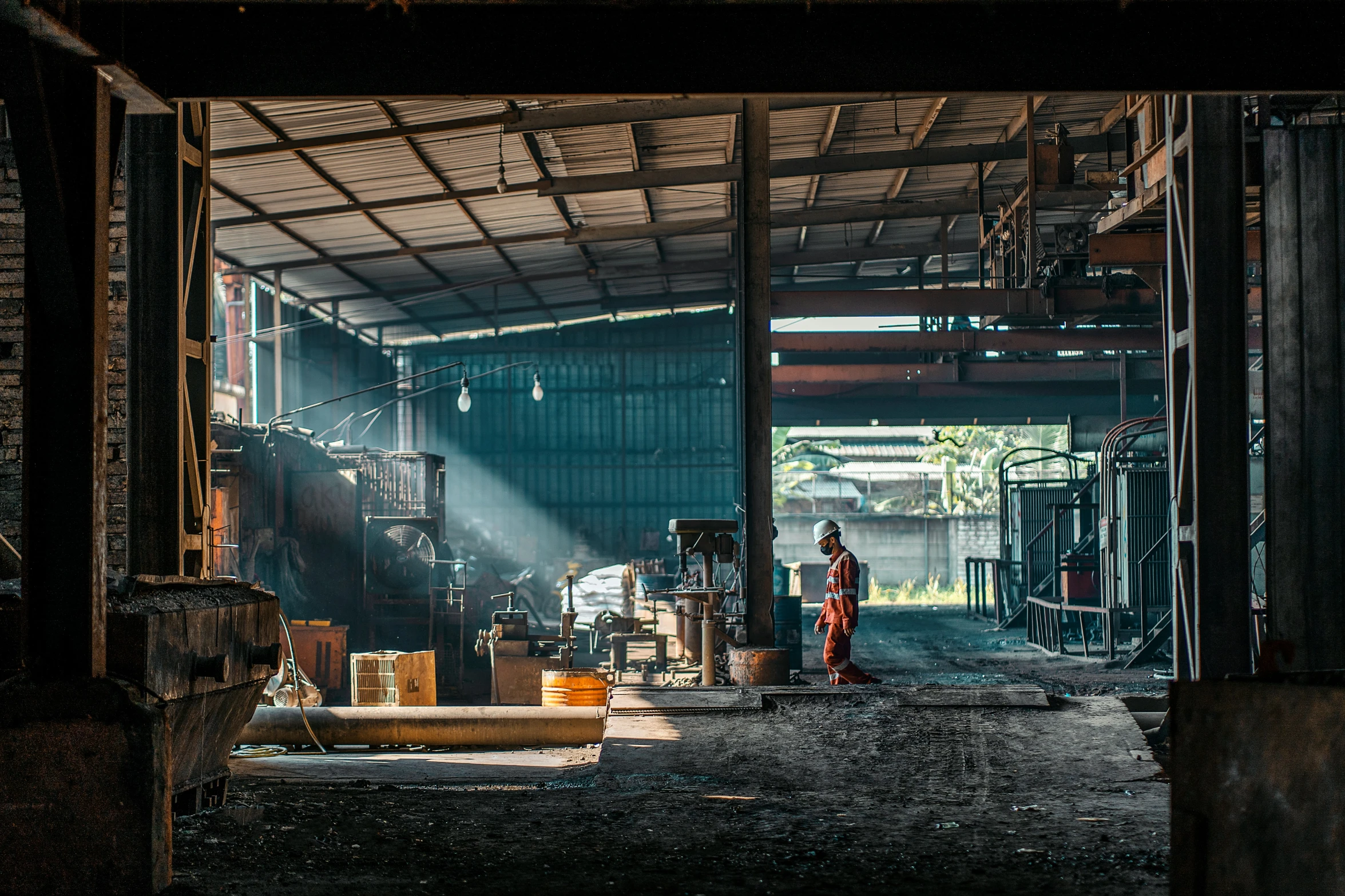 a man standing in a warehouse in front of a window