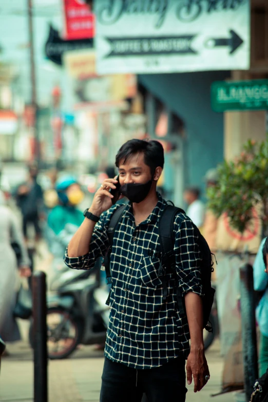 a man walking down the street while talking on a cell phone