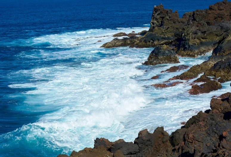 there is a rocky cliff that has some water on it