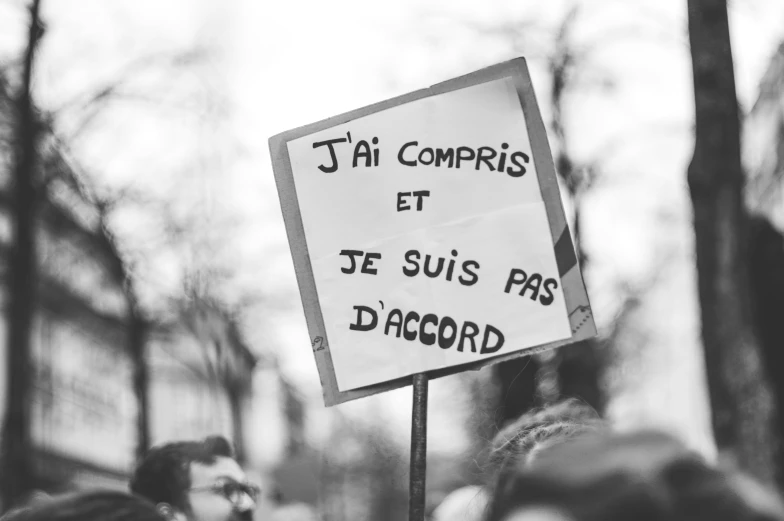 someone holding a sign in french that reads i'm comprise et je suis pass diacte