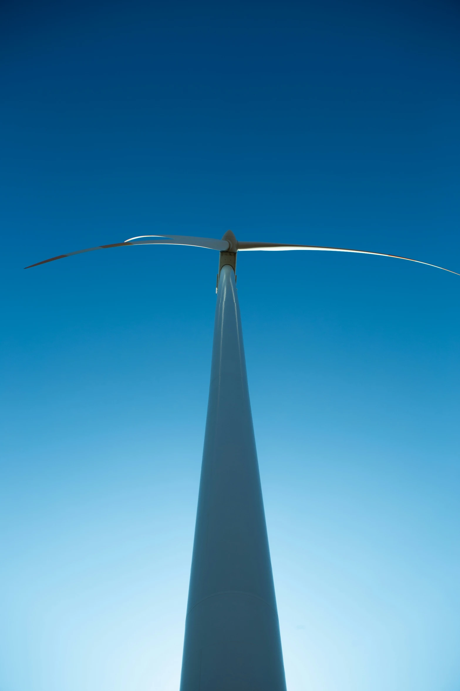 a large wind turbine is shown against the blue sky