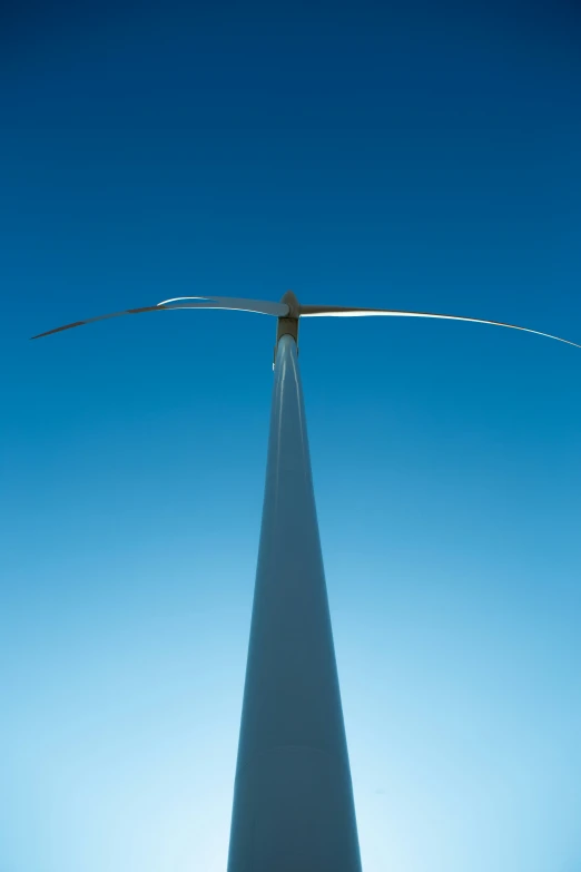 a large wind turbine is shown against the blue sky