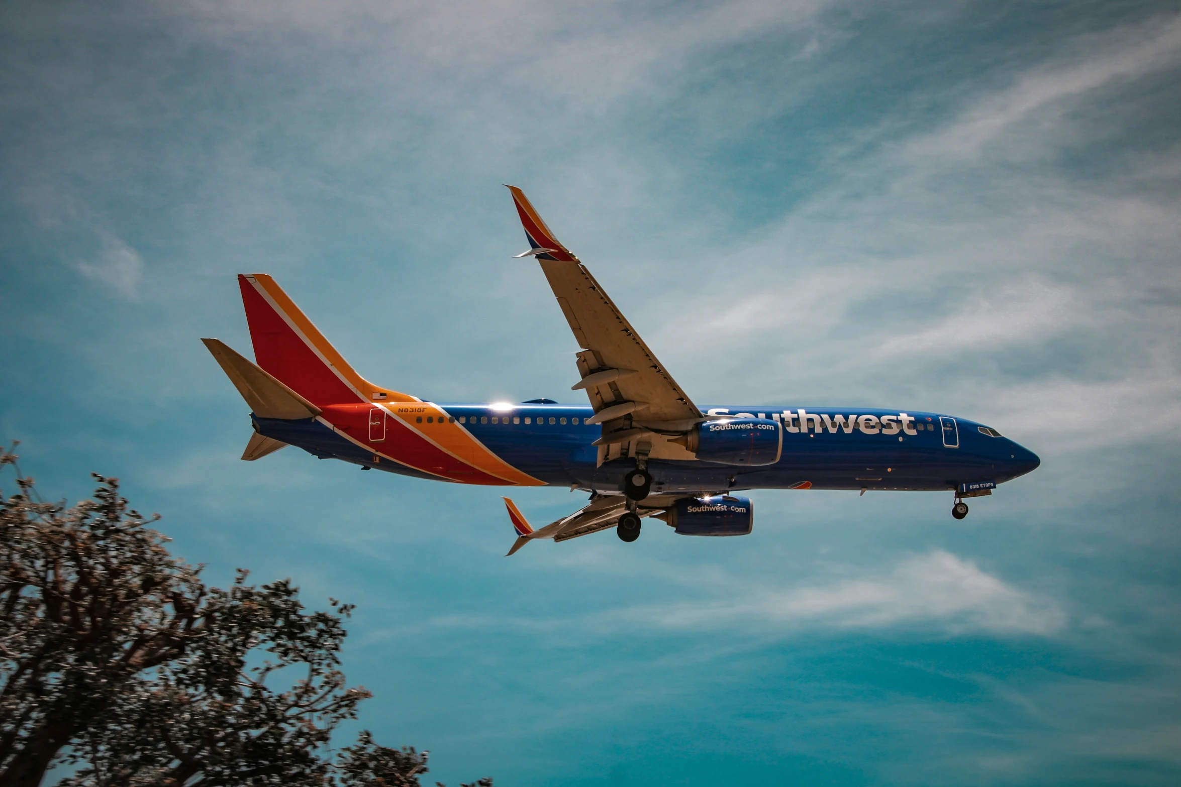 a blue and orange airplane is in the sky