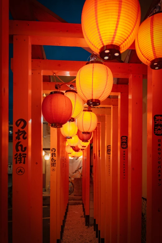 a hallway lined with red walls and lanterns hanging from the ceiling