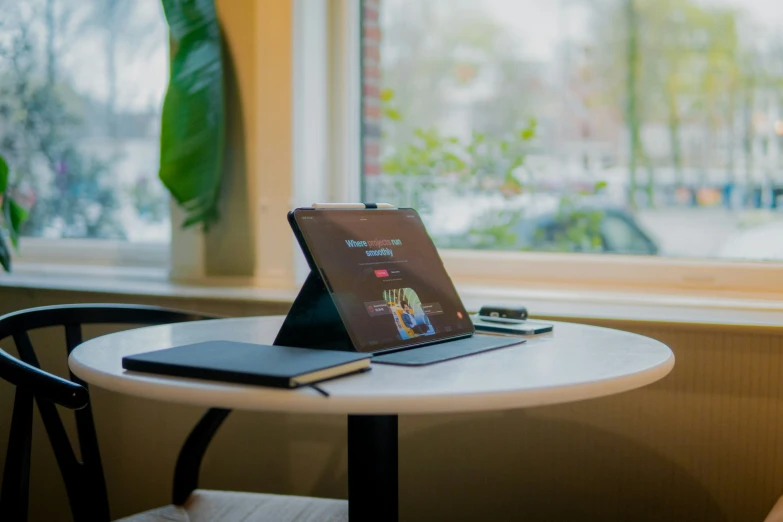 an office table has a tablet, mouse and keyboard on it