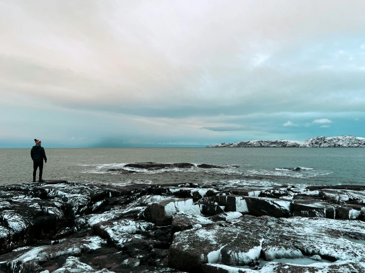 man standing at the edge of some large rocks