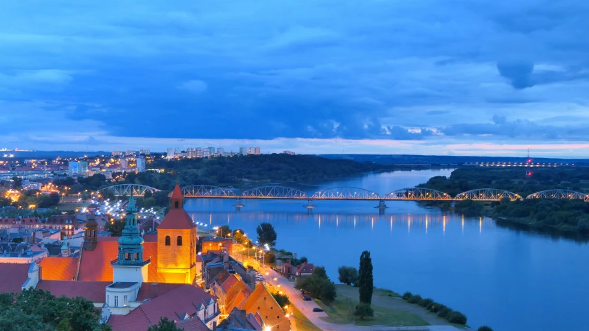 view of a large city with a beautiful lake and bridge