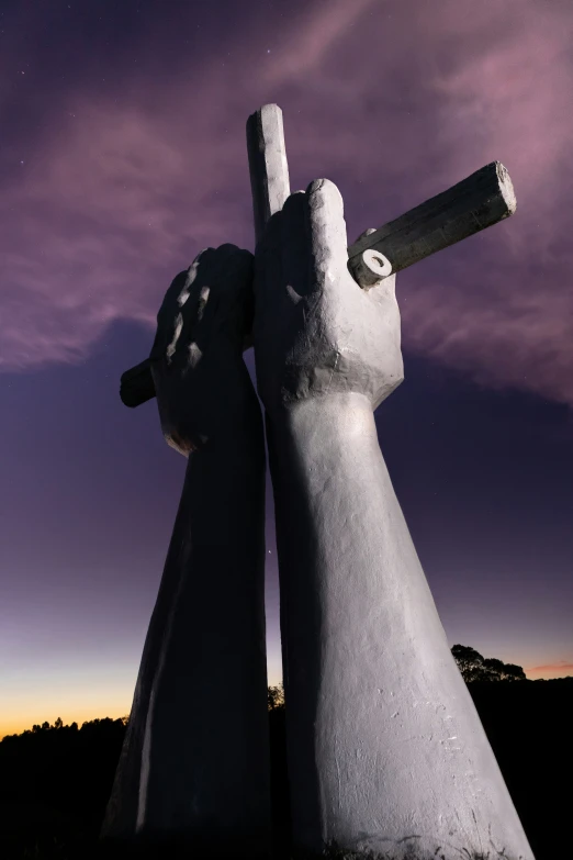 two fingers in the air by a large statue