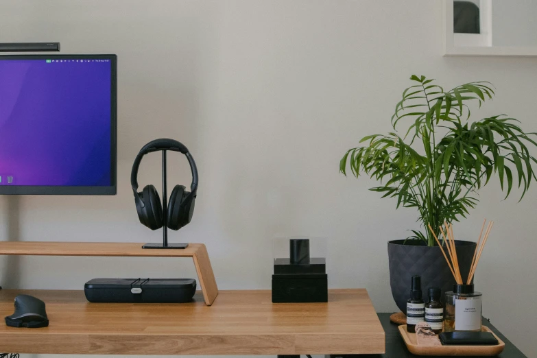 the computer monitor is next to earphones on the desk