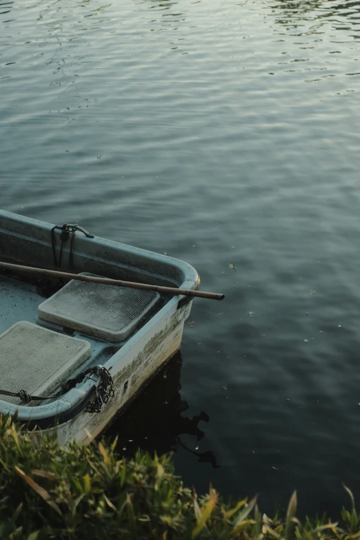 small boat sitting on calm water, in an open area