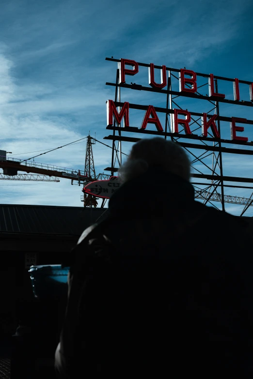 a man is walking towards the public market sign