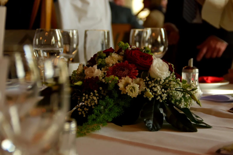 several glasses and table settings with a centerpiece on the table