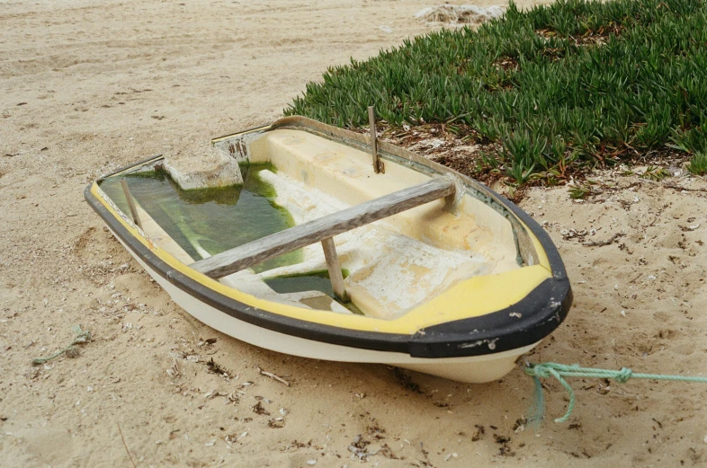 a small boat lies in the sand and rests on its side