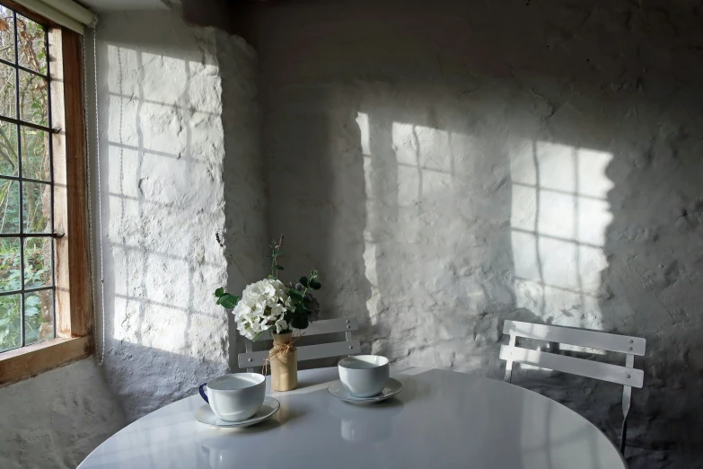 two empty cups and one vase sitting on a table